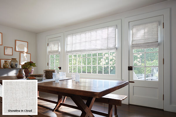 A weave like Flat Roman Shades made of Shoreline in Cloud hanging in a dining room is one of today's popular window treatment ideas
