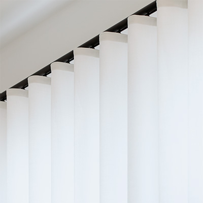 Close-up of ripple fold drapery used for curtains on arched windows with track hardware