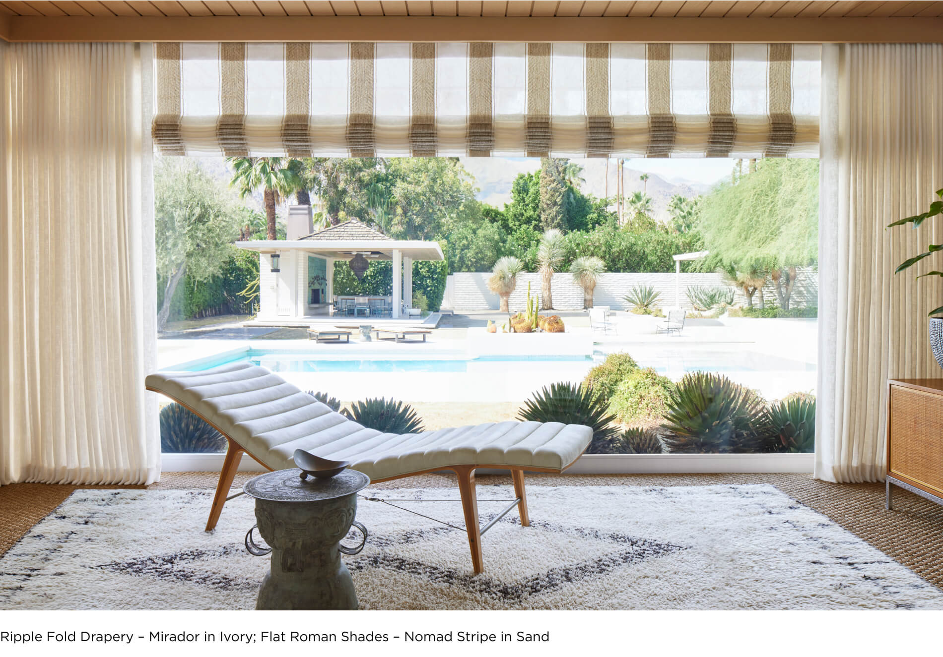 Large window overlooking the pool featuring ripple fold drapery featuring Martyn Lawrence Bullard's Nomad Stripe in Sand
