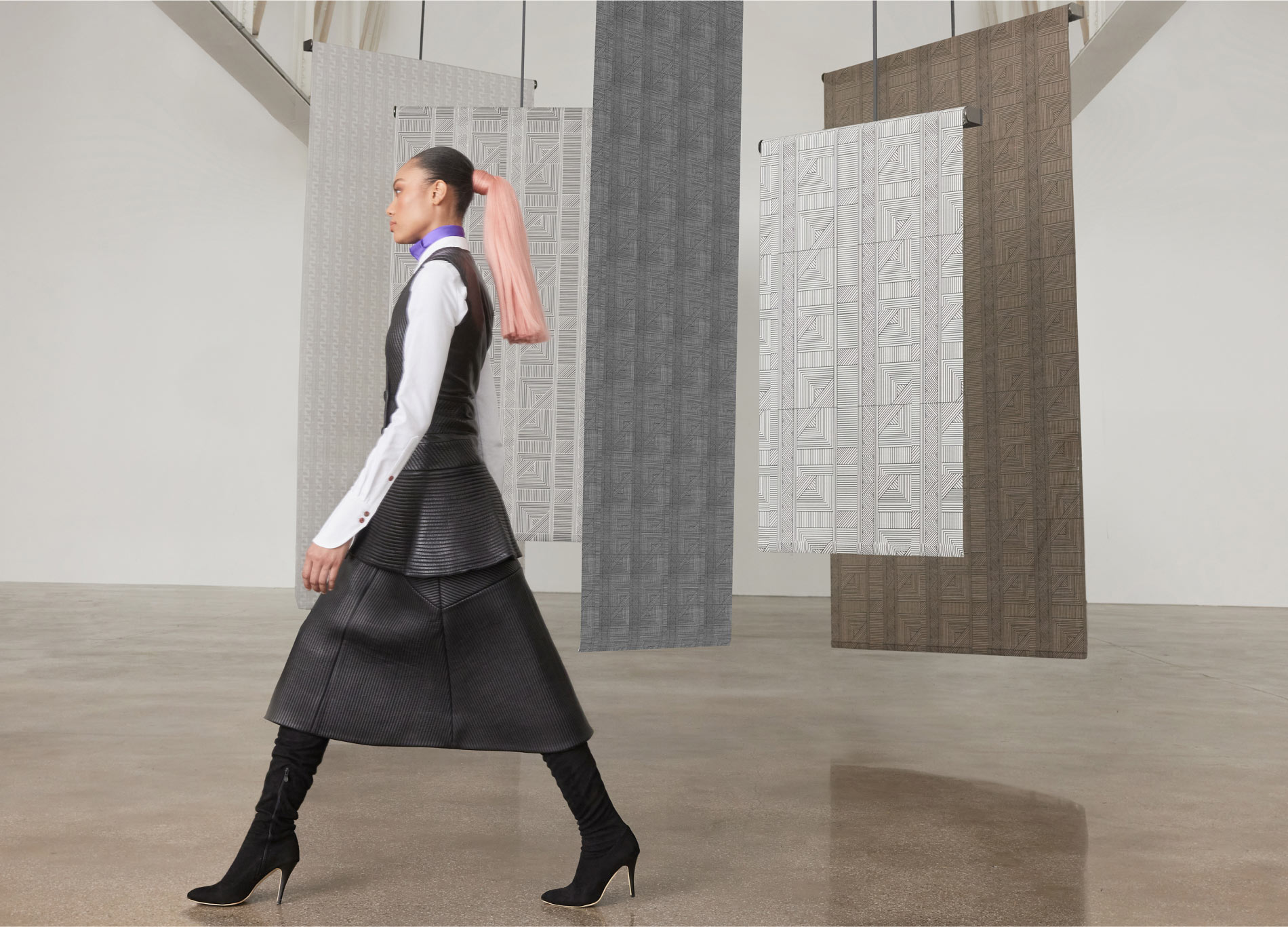 A model in Mimi Plange fashion design walking in front of the Mimi Plange collection materials
