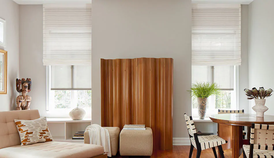 A modern room with Scandinavian-inspired dƩcor has lots of wood tones and Flat Roman Shades made of Sahara Stripe in Desert