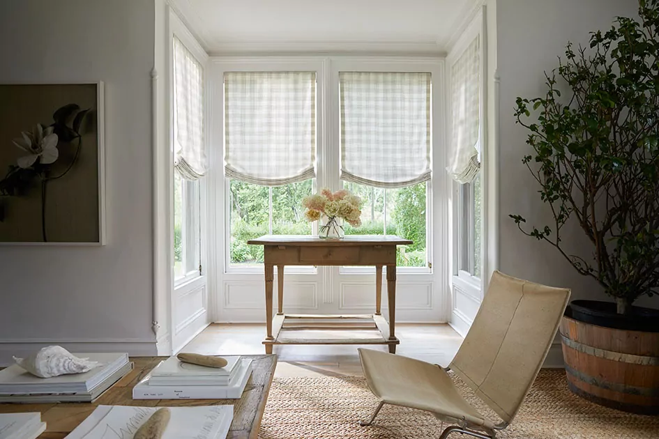 Breakfast nook with relaxed Roman shades in patterned fabric, showing different types of shades for windows with soft, decorative styling