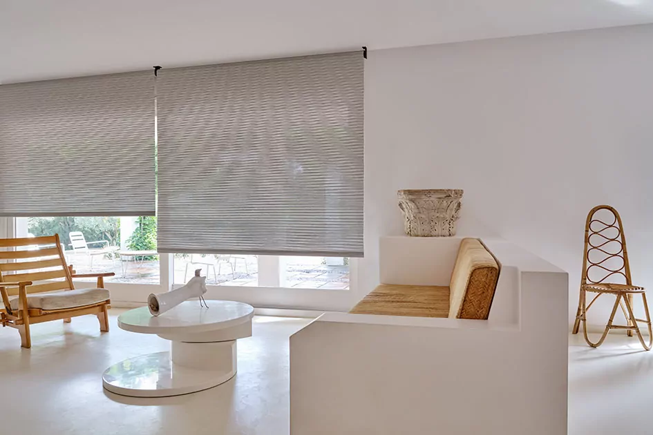 A living room with Scandinavian-inspired design and decor features reverse roller shades in Mesa Verde Mist