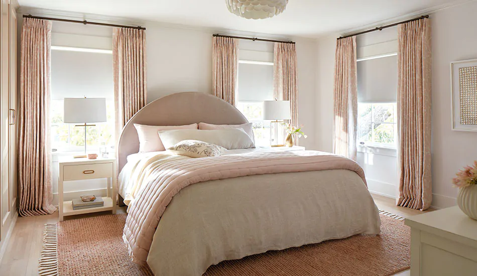 Tailored Pleat Drapery in Chinoiserie Blush in a pink bedroom, showing bedroom curtains touching the floor with a soft break length.